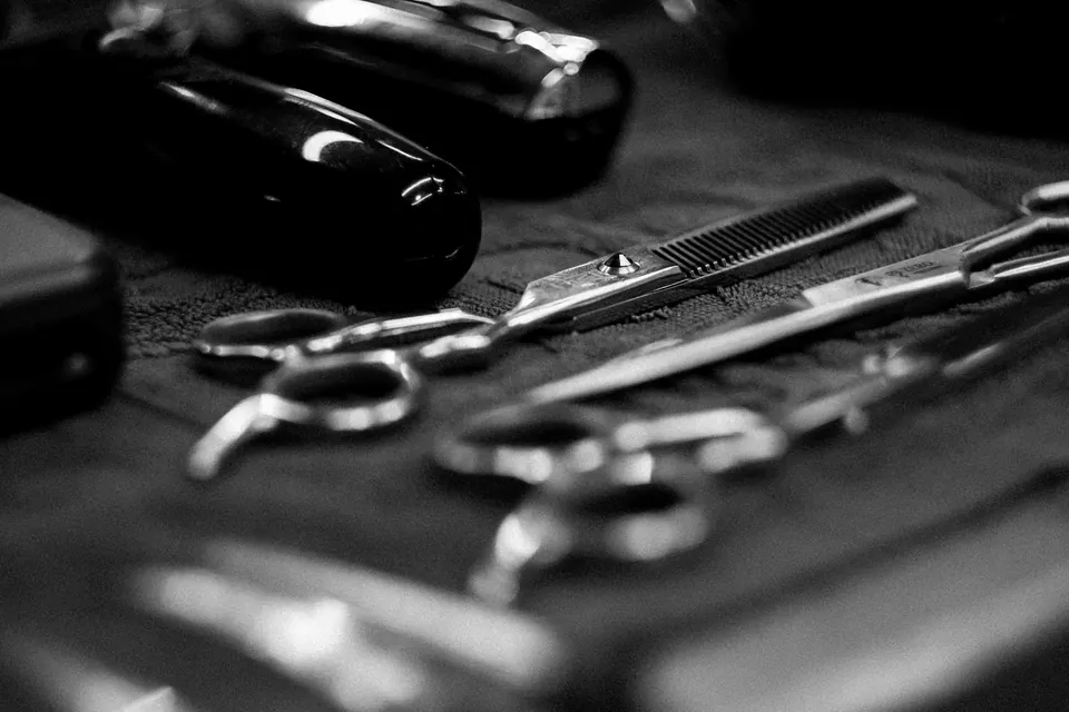 Schwarzweißaufnahme: Scheren und Kämme auf einer dunklen Ablage