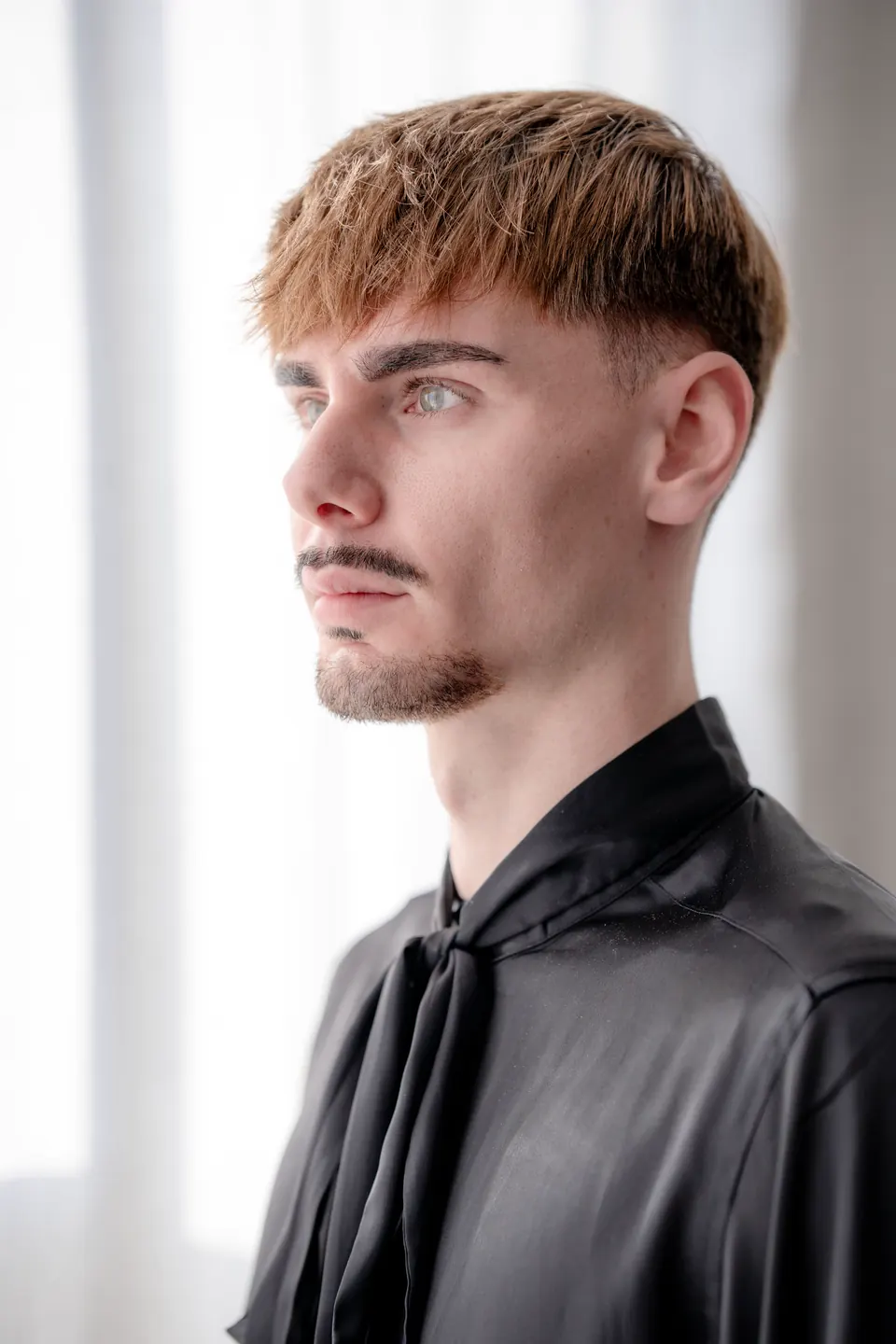 Porträt im Fensterlicht: junger Mann mit texturiertem Crop und kurzem Fade